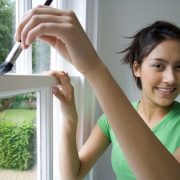 woman coloring an aluminum window with paint brush