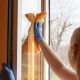 Girl cleaning aluminium windows with cloth