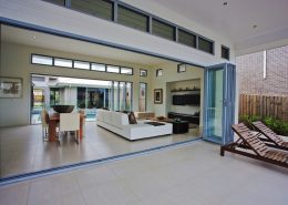 Open bi-fold doors opening into large living room with dining area