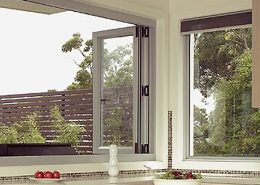 Open white frame aluminium bi-fold windows in a kitchen