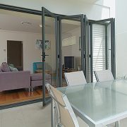 Bi-fold doors in a dining area opening into living room