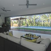 bi fold doors in a living room opening to a large pool area