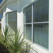 Outside view of double hung windows of a house with green lawn
