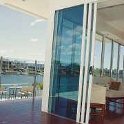 Tinted stacker doors opening to a river front view